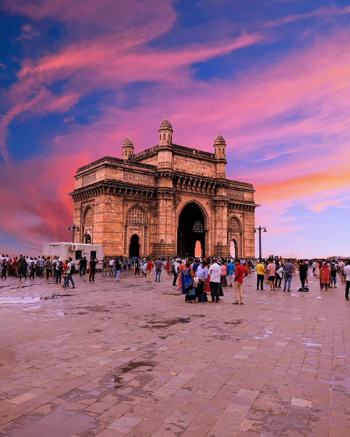 Gateway of India under a pink evening sky in Mumbai, on a self-guided audio walk